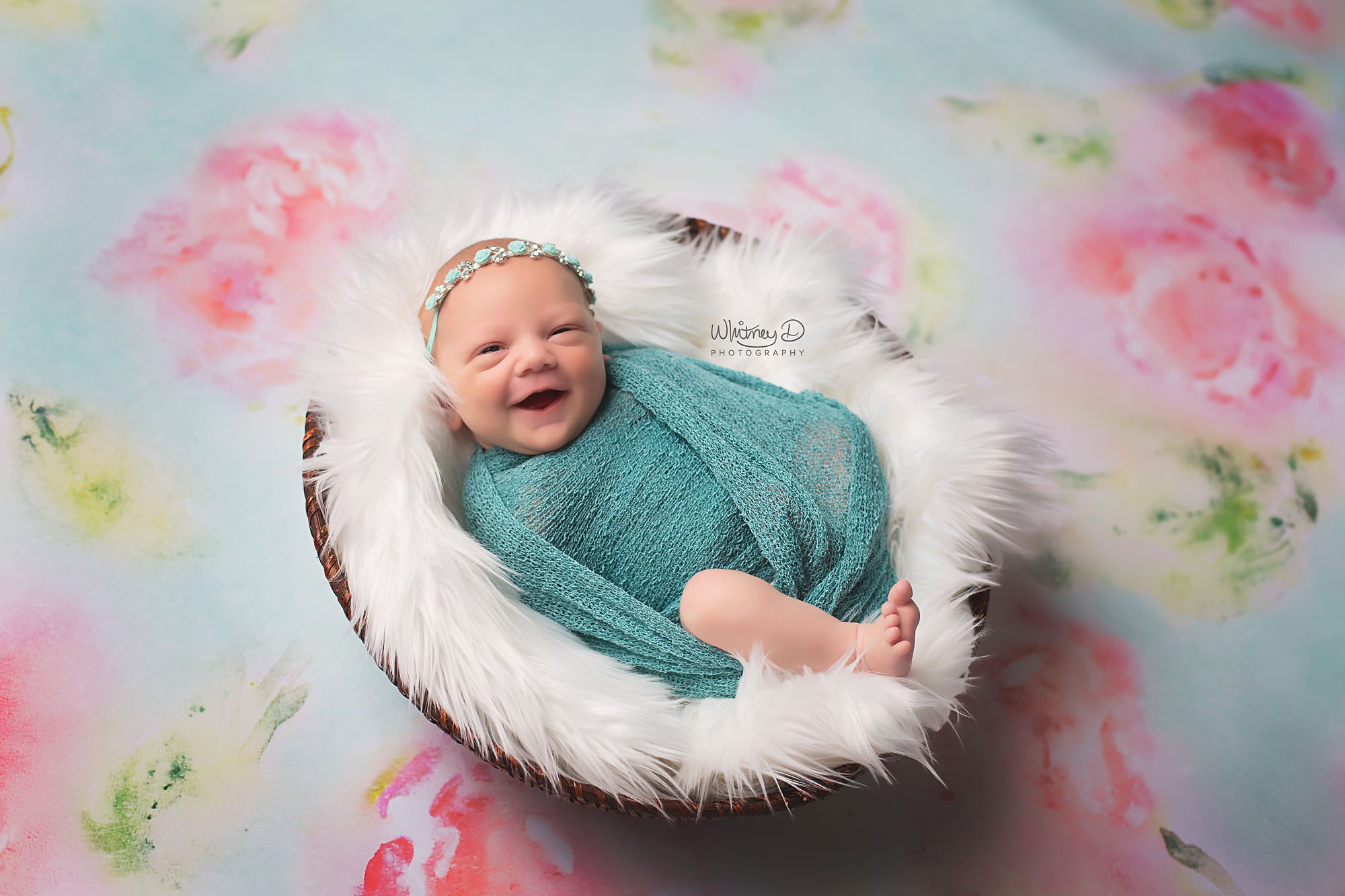Newborn baby girl smiling on floral background