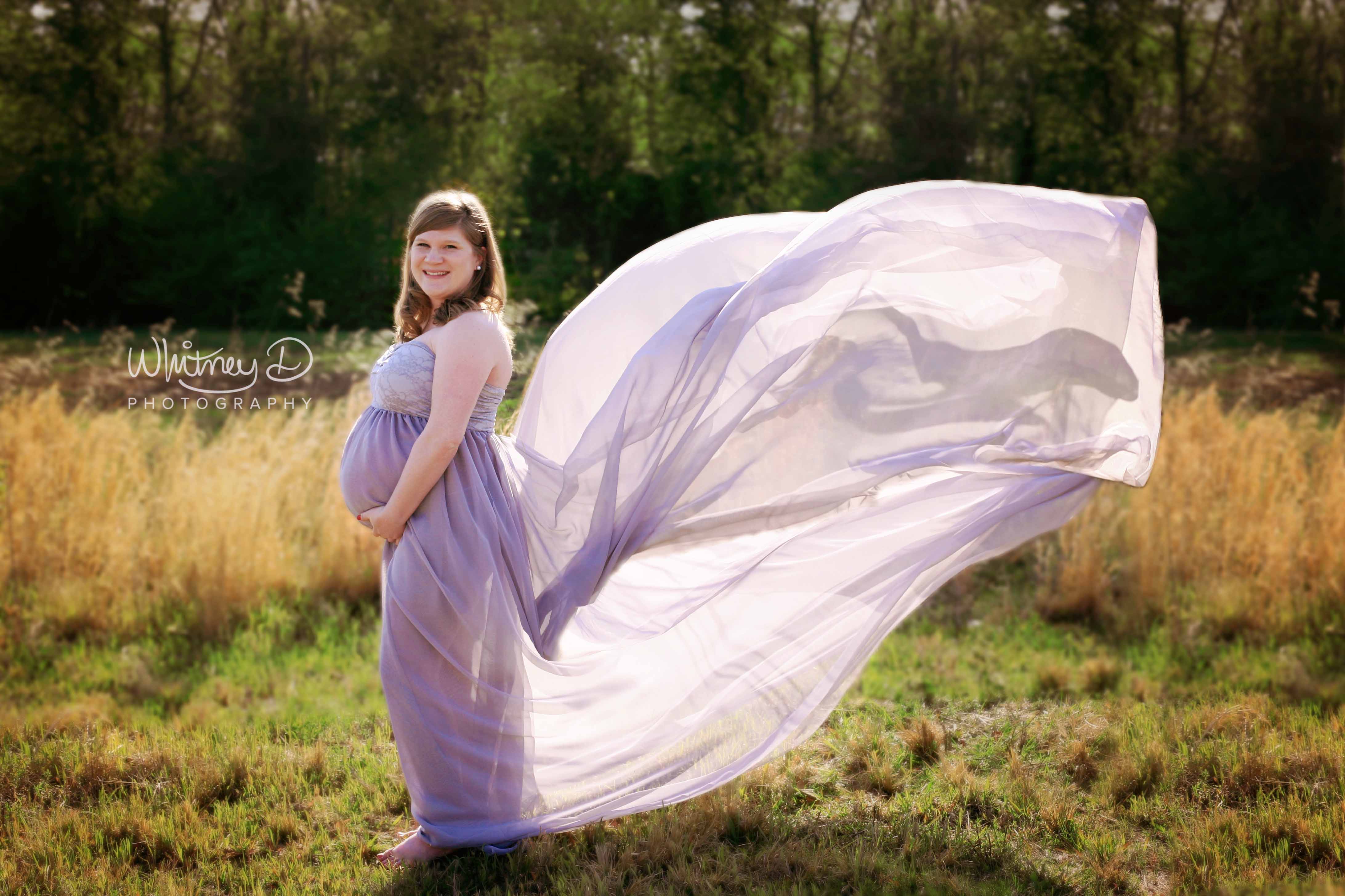 Glowing Pregnant Mom in flowing maternity gown in a field at Whitney D. Photography in Conway, Arkansas
