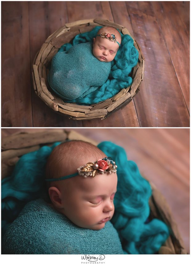 Newborn in teal wrap smiling at Whitney D. Photography in Conway, Arkansas