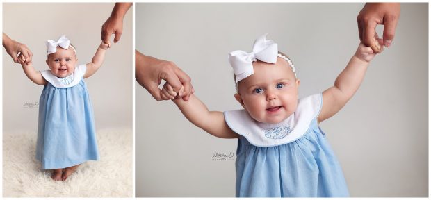 Baby girl holding parents hands at Whitney D. Photography in Conway, Arkansas