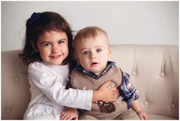 Baby boy with big sister on couch at Whitney D. Photography in Conway, Arkansas