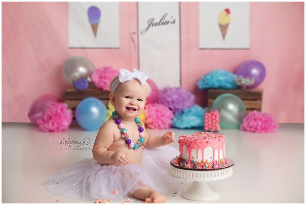 Baby girl eating ice cream cake at first birthday session at Whitney D. Photography in Conway, Arkansas