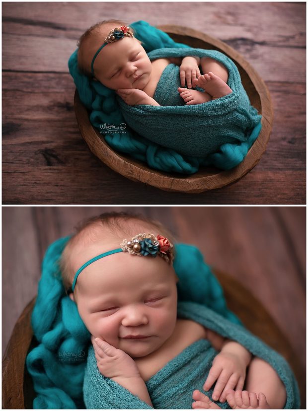 Newborn baby girl smiling in jewel tone wrap at Whitney D. Photography in Conway, Arkansas