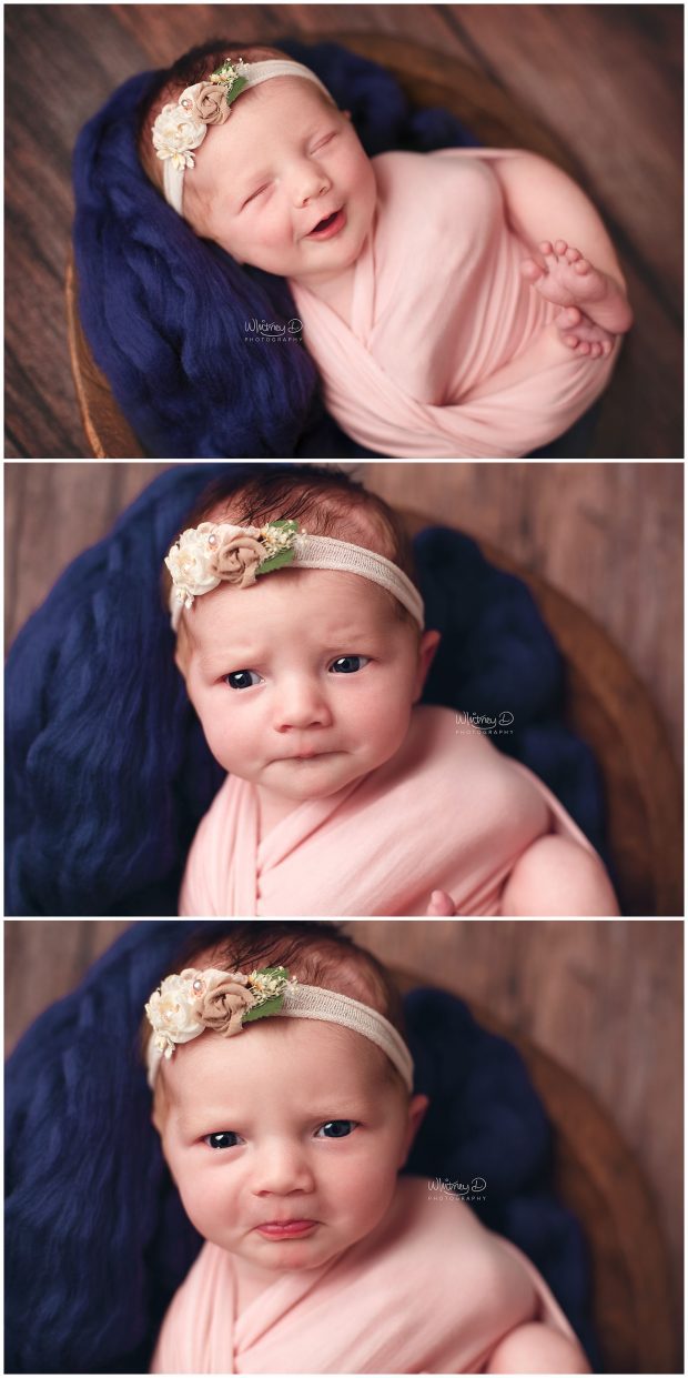 Newborn baby girl in pink wrap on navy giving a big smile at Whitney D. Photography in Conway, Arkansas