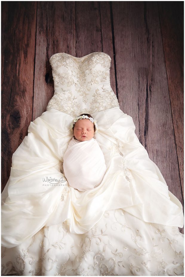 Newborn baby girl on mother's wedding dress at Whitney D. Photography in Conway, Arkansas
